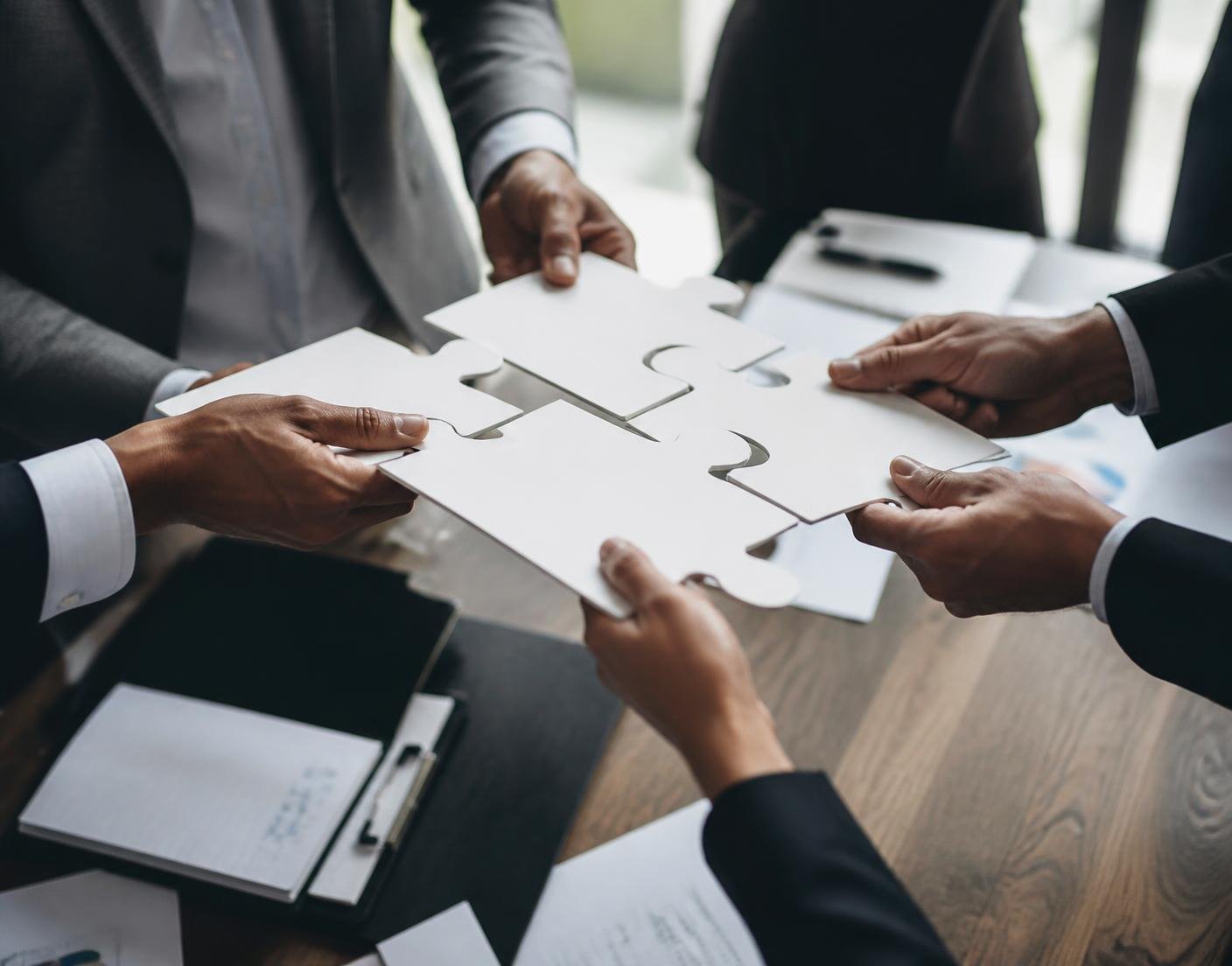 Business professionals joining puzzle pieces together as a team
