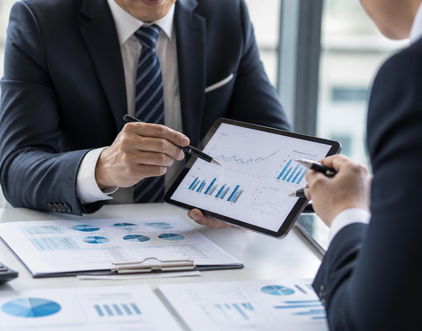 Business advisors reviewing growth performance charts on a tablet